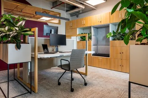 Groene kantoorruimte met bureau, houten maatwerkkasten en plantenbakken