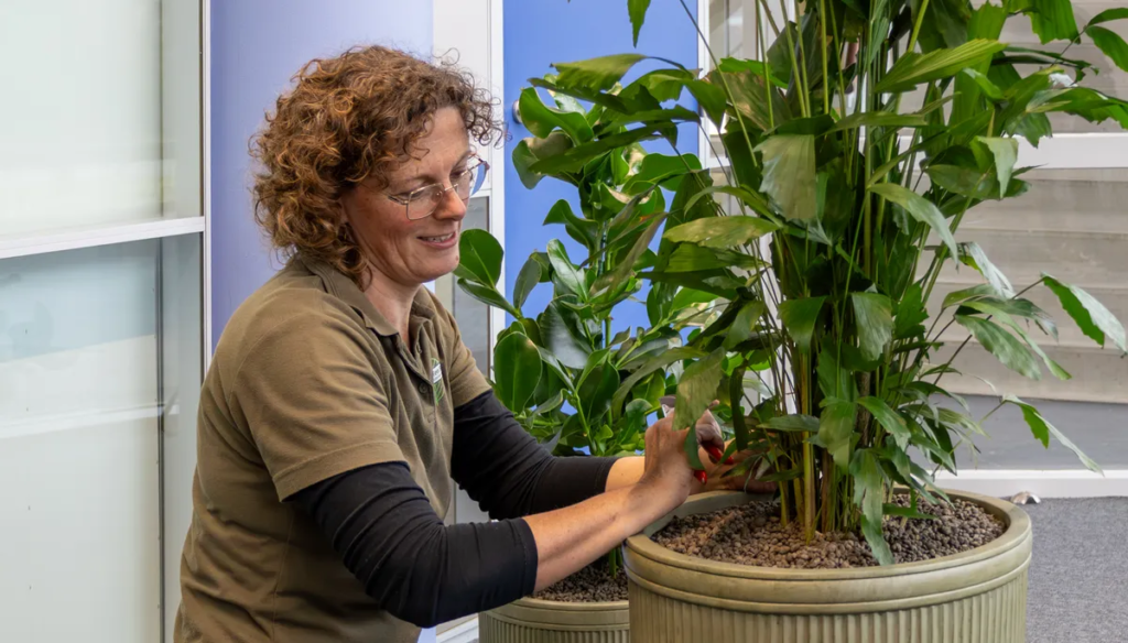 Onderhoudsmedewerkster Danielle aan het werk met beplanting