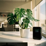 Monstera deliciosa plant naast luchtkwaliteitsmeter op wit bureau bij raam met natuurlijk zonlicht
