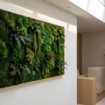 Mosswand met smaragdgroene en bosgroene texturen in een moderne, lichte entreehal met receptiebalie op de achtergrond.