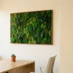 Levensecht moskunstwerk in smaragd- en bosgroen op moderne kantoorwand, met minimalistische eiken bureau en vetplant op de voorgrond.