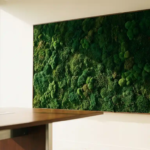 Mosswand met smaragdgroene en bosgroene texturen in een moderne vergaderruimte, met een strakke tafellrand op de voorgrond.