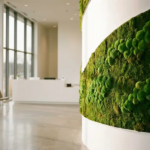 Weelderige groene mosmuur langs gebogen witte cilindervormige wand in modern minimalistisch kantoor met natuurlijk licht