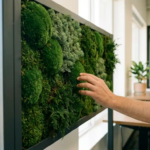Levende moswand met drie verschillende mossoorten in smaragdgroene tinten op donkergrijze lijst in modern kantoor