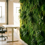Levendige moswand in moderne kantooromgeving met waterdruppels op smaragdgroene texturen, wit bureau en ergonomische stoel, natuurlijk licht door grote ramen