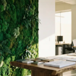 Luxueuze moswand met smaragdgroene texturen naast witte muur in modern kantoor met houten bureau en architectuurmonsters